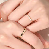 Hands wearing diamond slim ring and matte panel band stacked on adjacent fingers